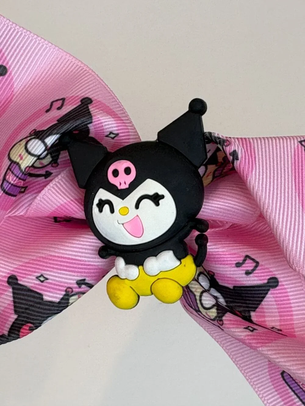 Cute pink Sanrio hair bow featuring Kuromi and an all-over Kuromi pattern. New